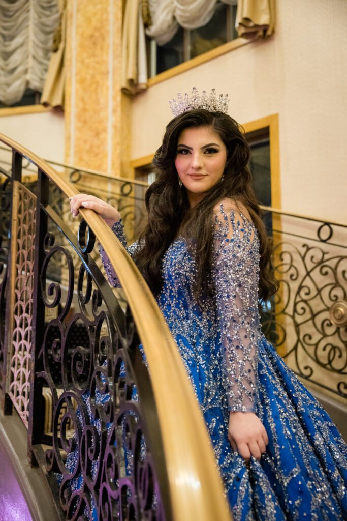 Sweet 16 celebrant in a blue gown on the staircase