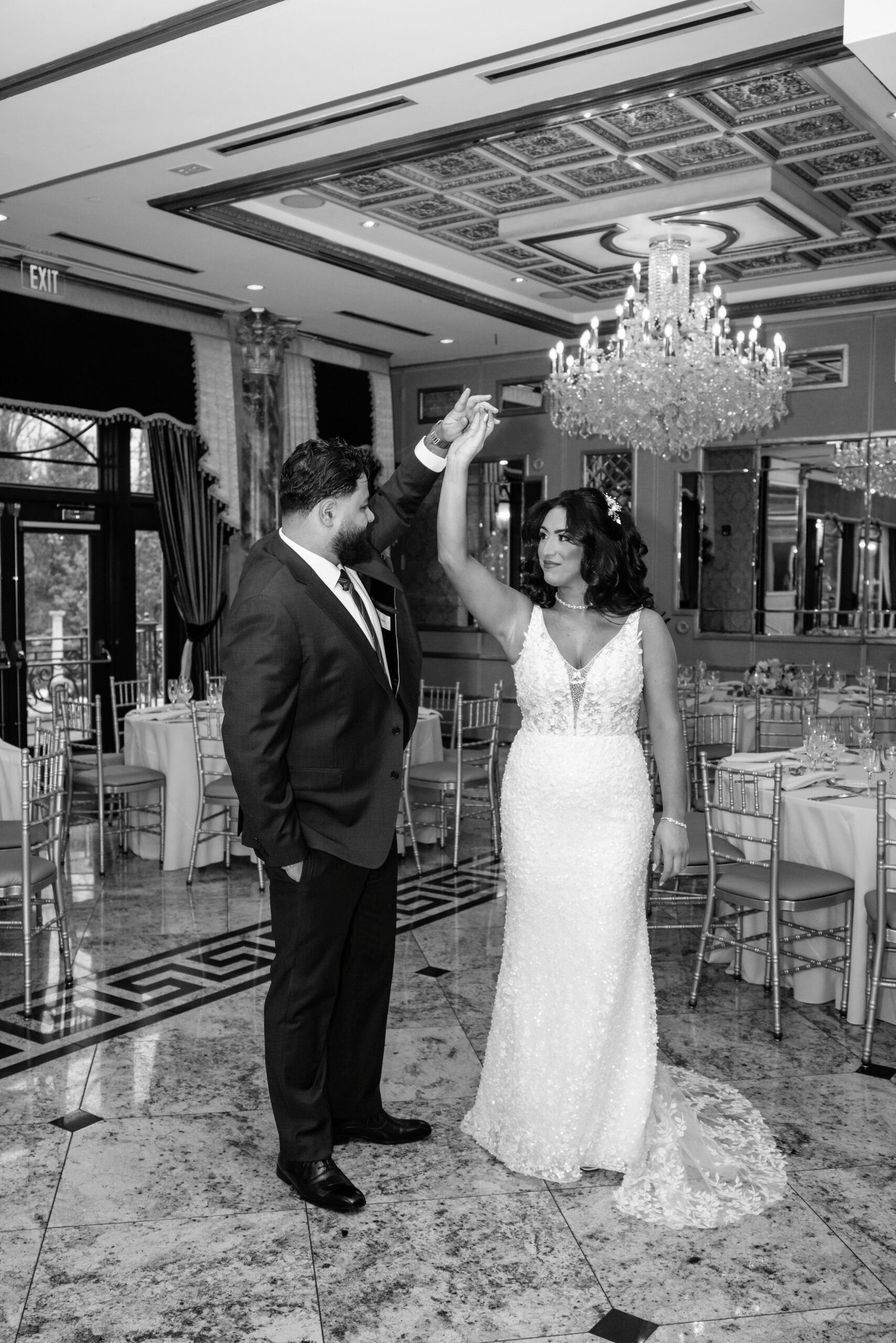 Black and white photograph of the couple celebrating with arms raised