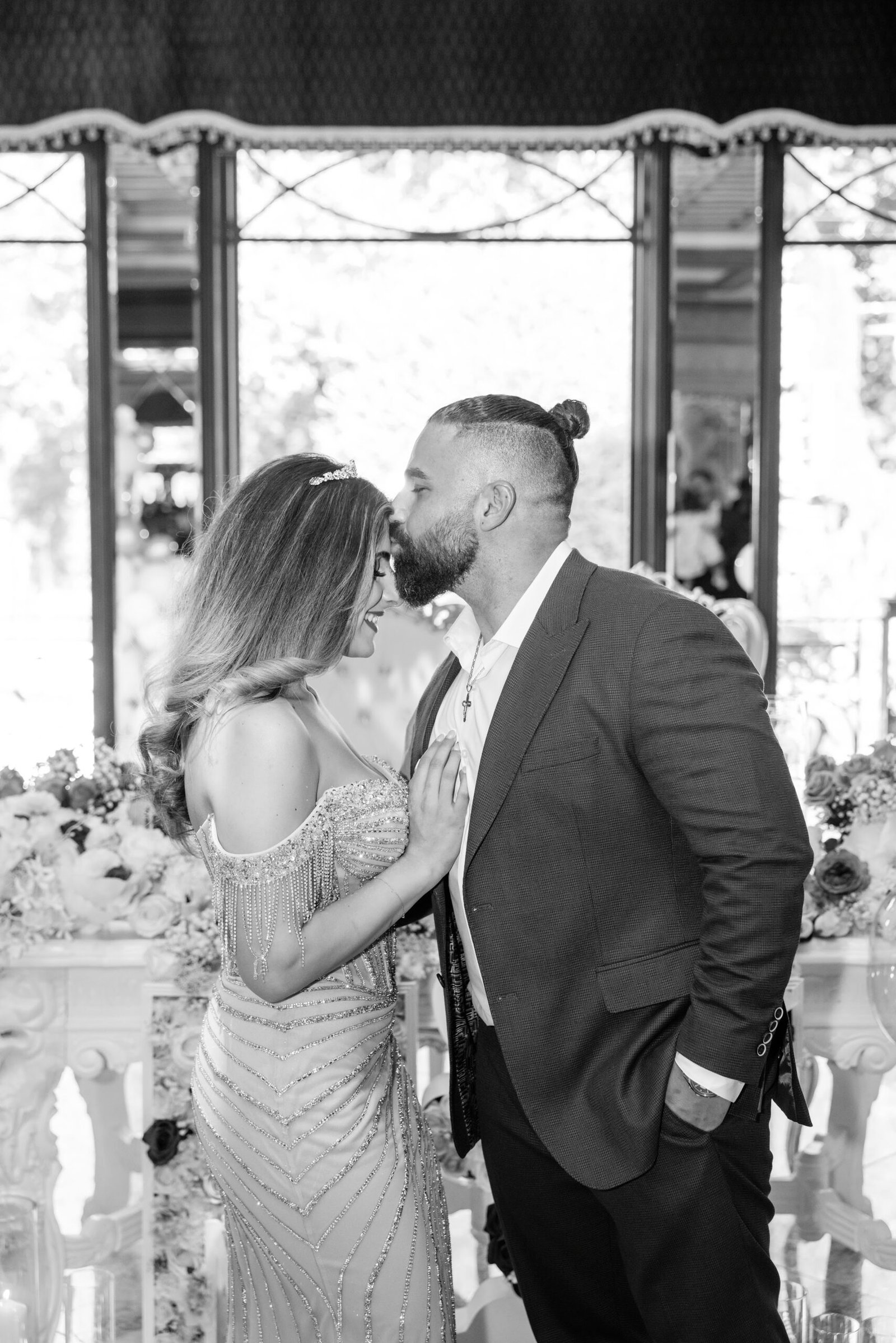 Black and white photograph of the couple sharing a kiss at their engagement party