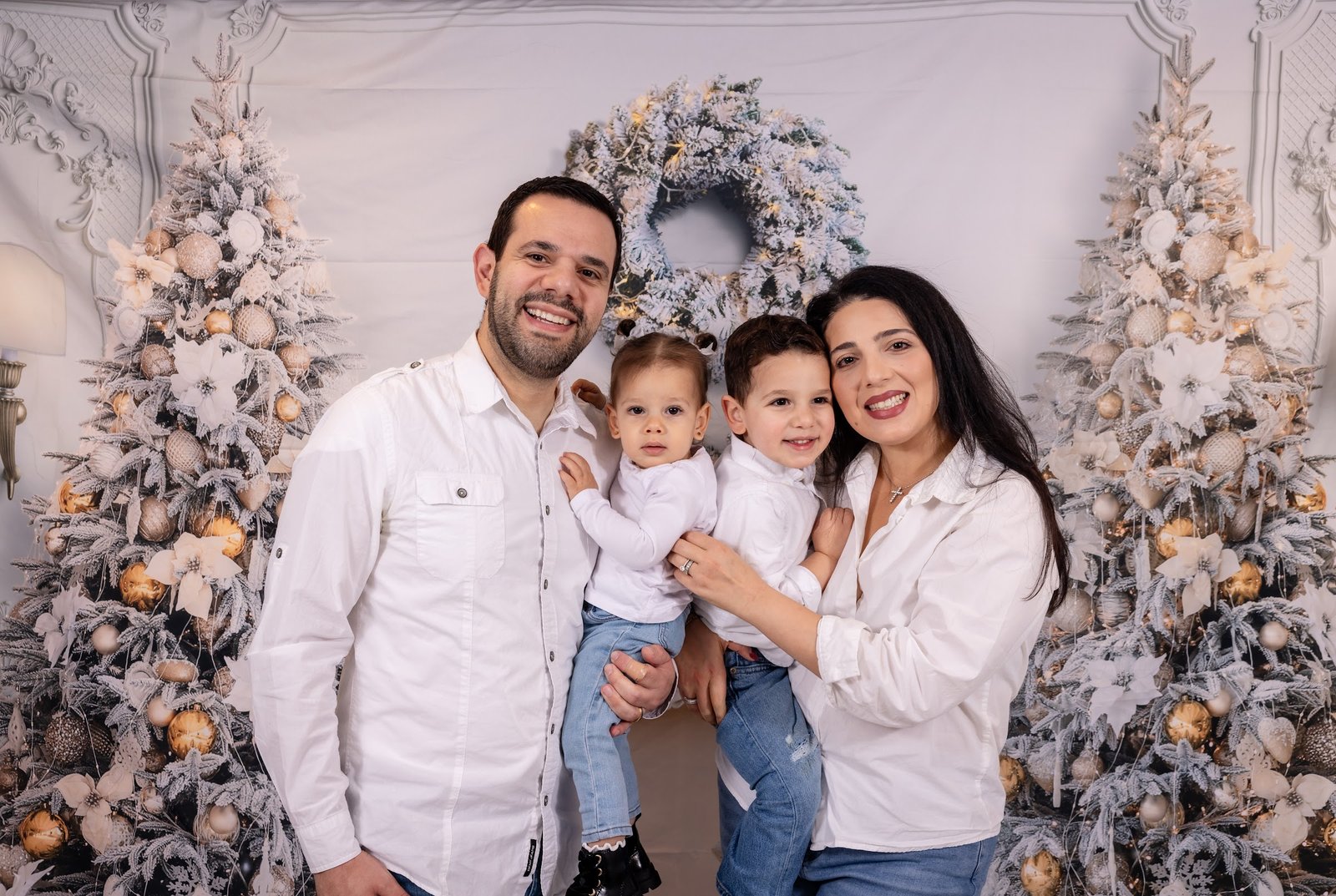 Family gathered around a white Christmas tree