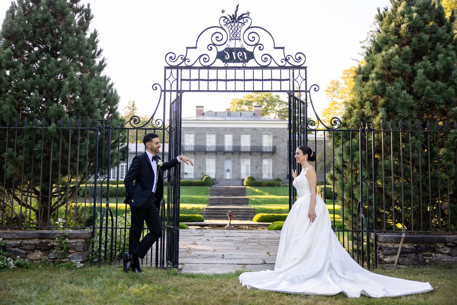 Bride and groom framed by the estate gates